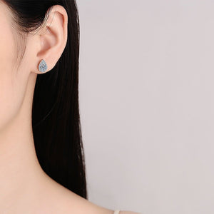 Close-up of a woman wearing a diamond earring on a plain background