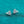 Teardrop-shaped earrings with gemstones on a teal glittery background