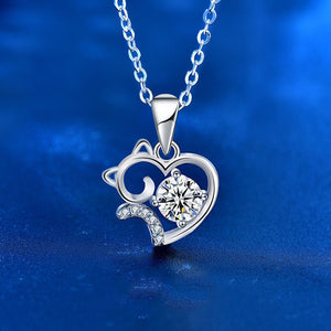 Silver pendant with heart and cat design on a blue background