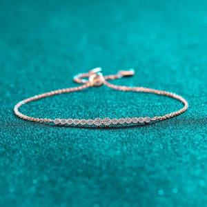 Delicate bracelet with small stones on a teal background