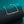 Silver necklace on a black cushion with a teal background