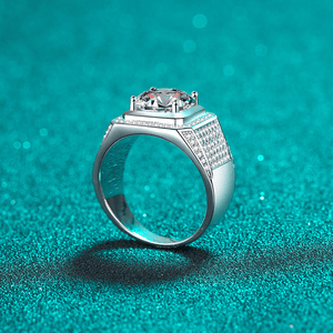 Silver ring with a large central gemstone on a teal background