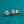 Gold earrings with clear moissanite on a teal glittery background