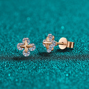 Gold earrings with clear moissanite on a teal glittery background