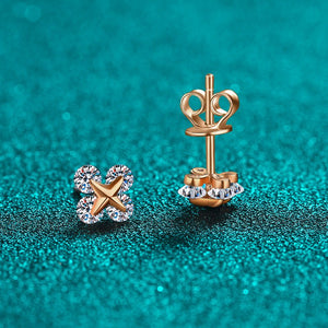 Gold earrings with star and moissanite designs on a teal background