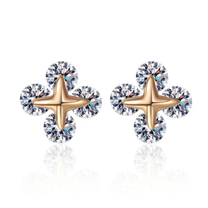 Pair of earrings with gold star-shaped centers and clear gemstones on a white background