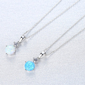 Two silver necklaces with opal pendants on a light gray background