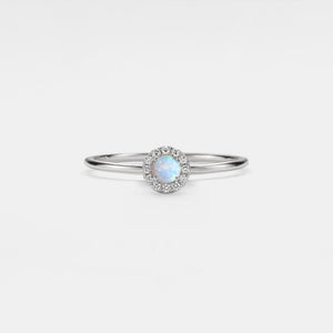 Silver ring with a central gemstone on a light gray background