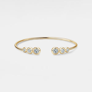 Gold bracelet with small diamonds on a light gray background