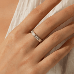 Silver ring on a person's finger with a soft background