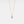 Gold necklace with a diamond pendant on a light gray background