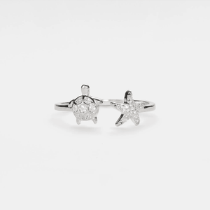 Silver ring with sea turtle and starfish design on a white background