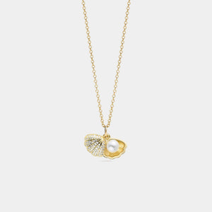 Gold necklace with a heart and pearl pendant on a light gray background
