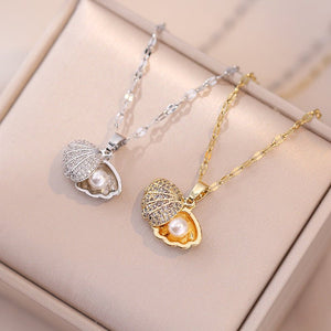 Two pearl pendants on gold and silver chains on a beige surface