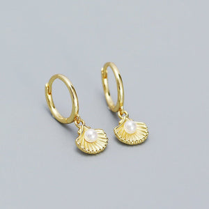 A set of hoop earrings with seashell and pearl charms, available in silver and gold color options.