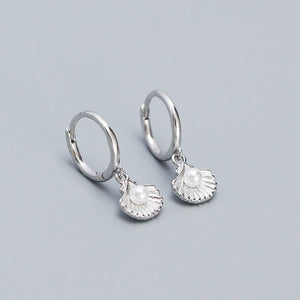 A set of hoop earrings with seashell and pearl charms, available in silver and gold color options.