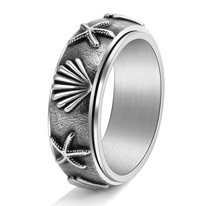 Silver ring with starfish and shell designs on a white background
