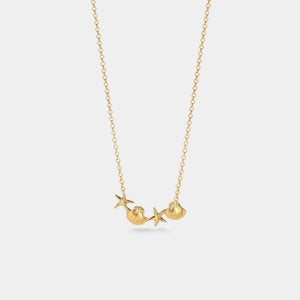 Gold necklace with a mermaid pendant on a light gray background