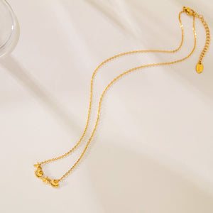 Gold necklace on a light beige surface