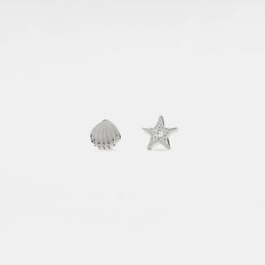 Silver shell and starfish-shaped earrings on a light gray background