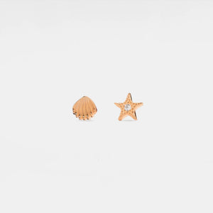 Rose gold shell and starfish-shaped earrings on a light gray background