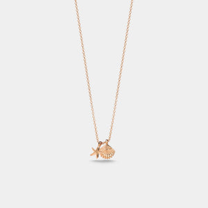 Rose gold necklace with a shell and starfish pendant on a light gray background