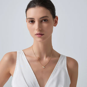 Woman wearing a gold necklace with a white background