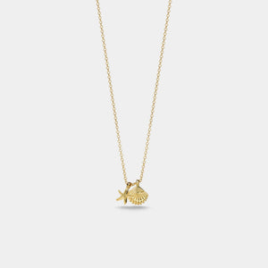 Gold necklace with a fish and shell pendant on a light gray background