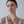 Model wearing a gold ring with starfish and shell design on a light gray background