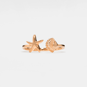 A rose gold-colored ring featuring a starfish and a seashell design, crafted from solid 925 sterling silver with a hypoallergenic finish.