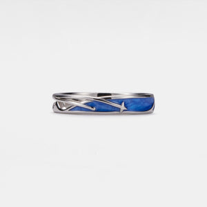 Silver ring with blue inlay on a white background