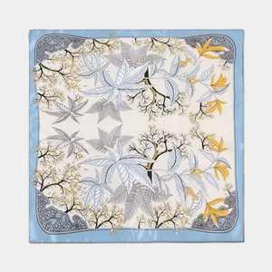 Square scarf with tree and leaf pattern on a light blue background
