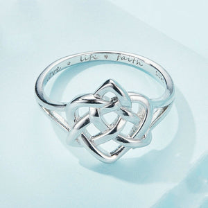 Silver interwoven ring on a light blue background