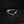 Gold triangle-shaped ring with a diamond on a black background