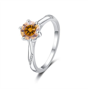 Silver ring with a round orange gemstone on a white background