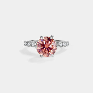 Pink gemstone ring with diamond accents on a white background