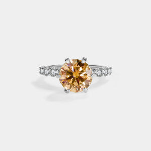 Diamond ring with a yellow gemstone on a white background