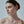 Woman with a bun hairstyle and earring on a plain background