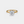 Gold ring with a diamond on a light gray background