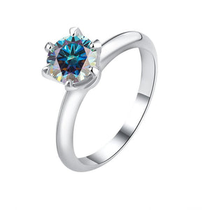A solitaire color moissanite engagement ring with a hypoallergenic finish, set in a sterling silver band.
