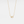 Gold necklace with a small pendant on a light gray background