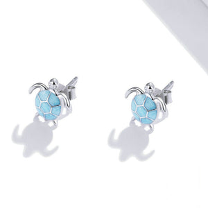 Sea turtle-shaped earrings with blue enamel design on a white background