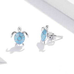 Sea turtle-shaped earrings with blue enamel design on a white background
