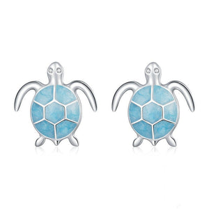 Sea turtle-shaped earrings with blue enamel design on a white background
