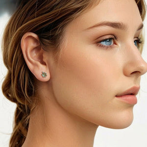 Close-up of a woman wearing a blue gemstone sea turtle earring with a blurred background