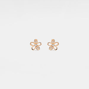 Rose gold flower-shaped earrings with clear stones on a light gray background