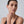 Woman wearing a black top against a plain background
