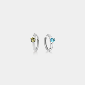 A pair of gold hoop earrings with red and green gemstones.