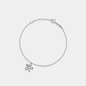 A gold-plated sterling silver bracelet with a small flower charm, featuring a chain structure and a gold-plated flower-shaped charm.