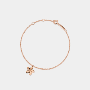 A gold-plated sterling silver bracelet with a small flower charm, featuring a chain structure and a gold-plated flower-shaped charm.